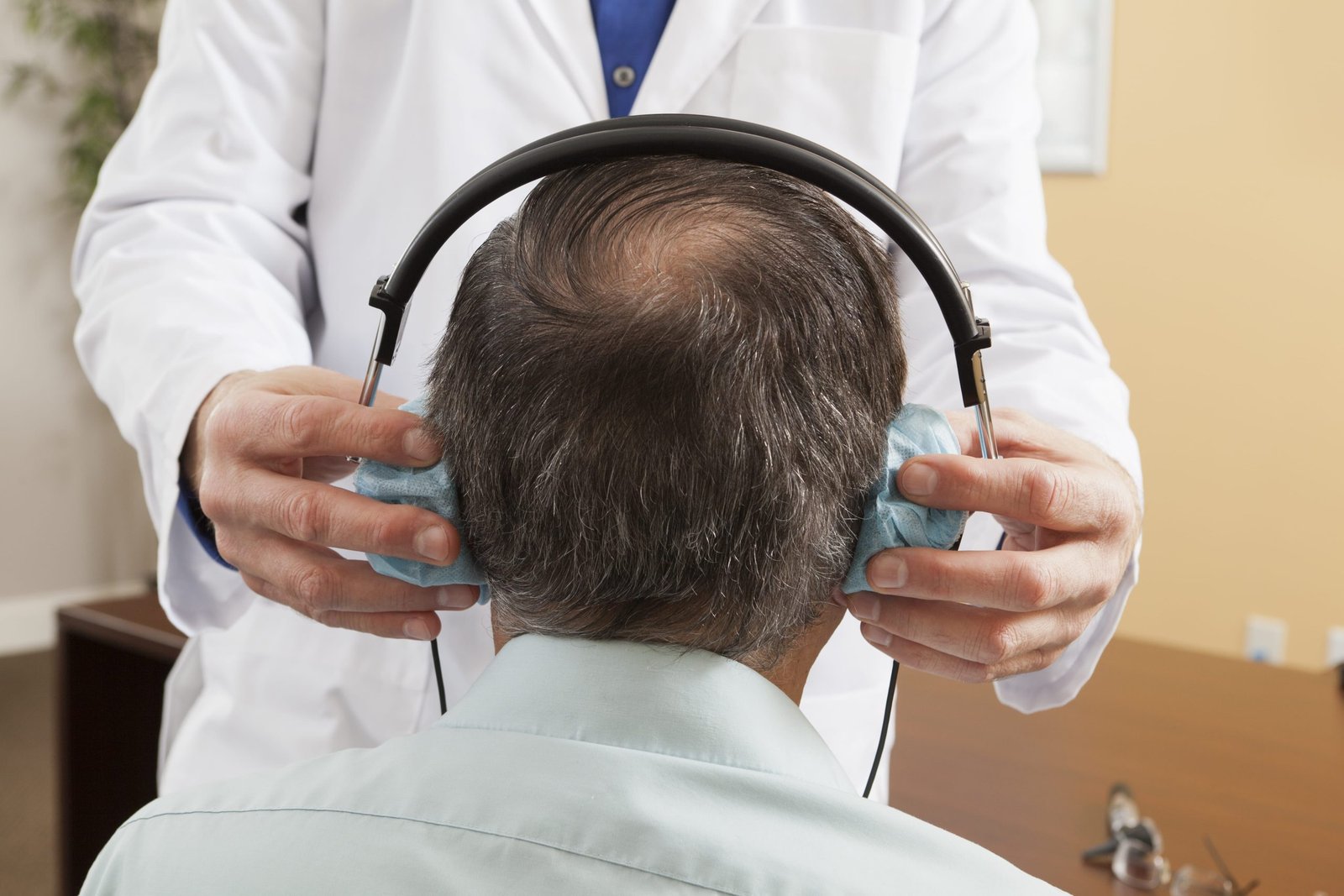 Audiologist placing a headset on a patient for audiometric evaluation